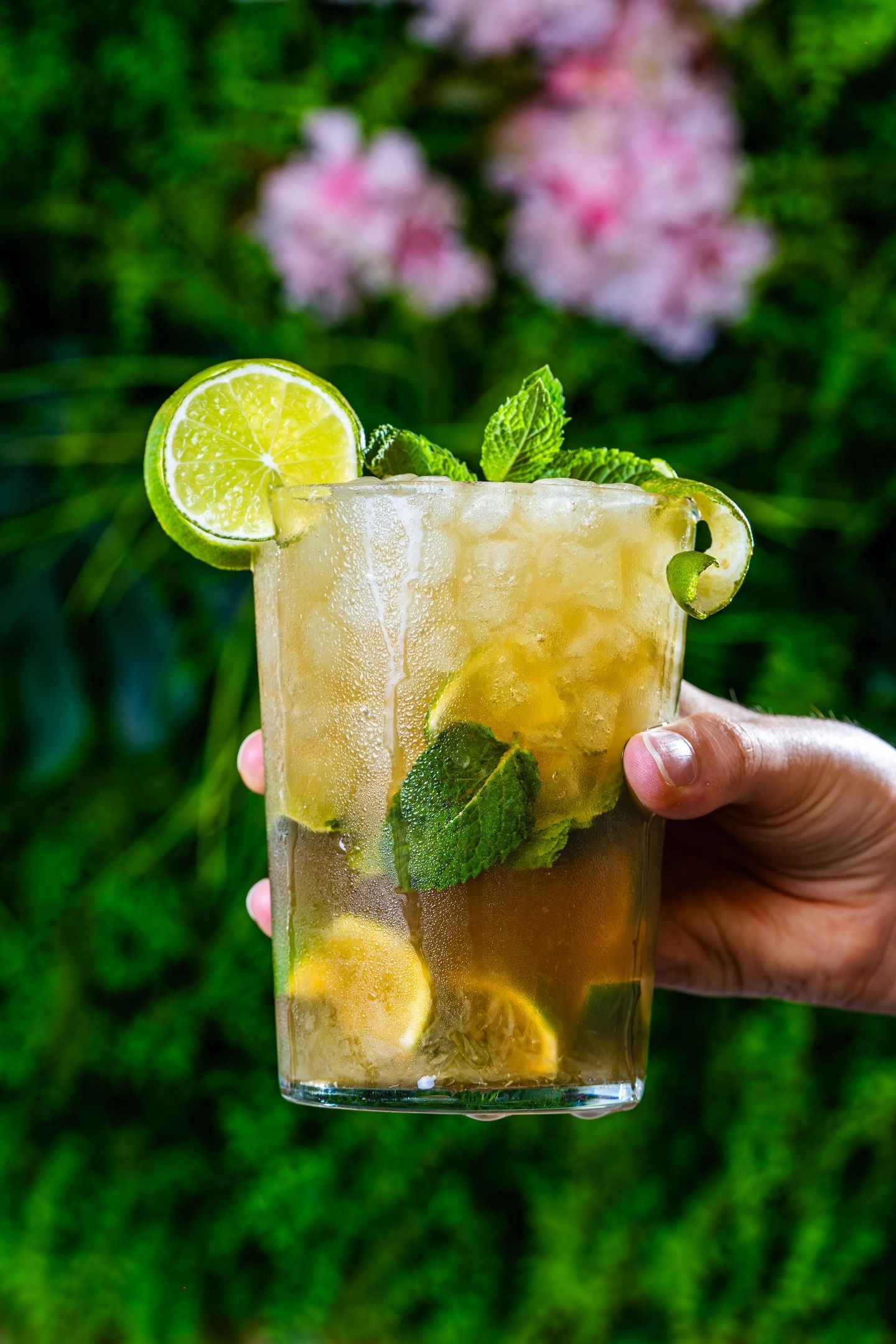 Mojito au citron vert et à la menthe, tenu à la main